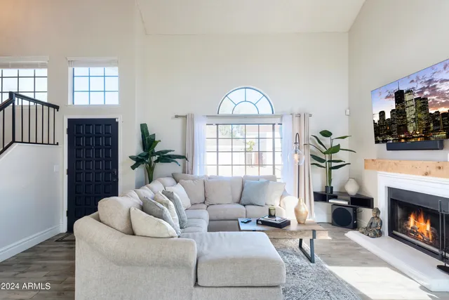 a living room with furniture a potted plant and a fireplace
