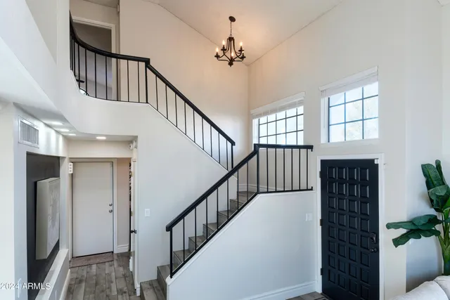 a view of staircase with lots of frames on wall and a window