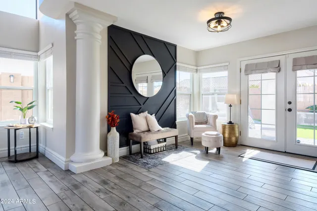 a living room with furniture a wooden floor and a large window