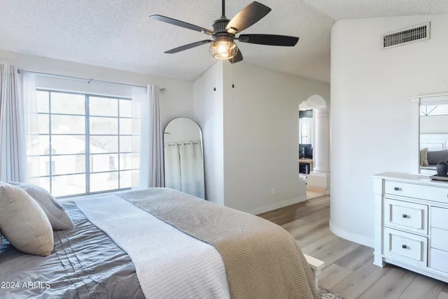 a bedroom with a large bed and a chandelier