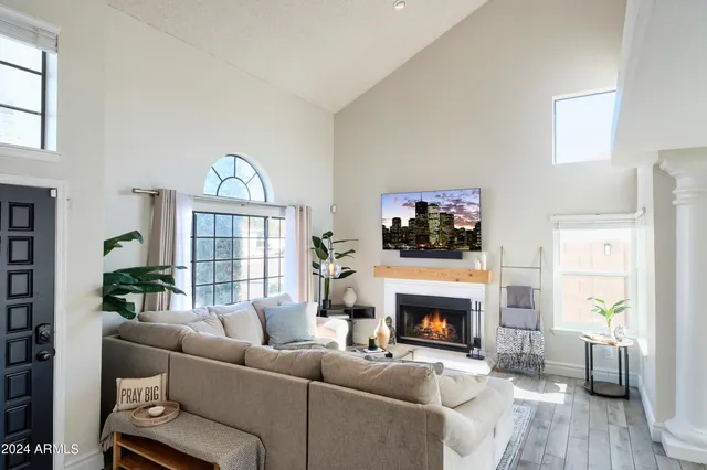 a living room with furniture a flat screen tv and a fireplace
