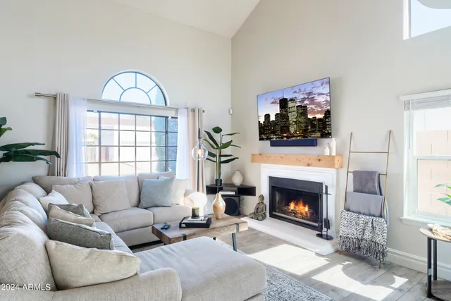 a living room with furniture a fireplace and a flat screen tv