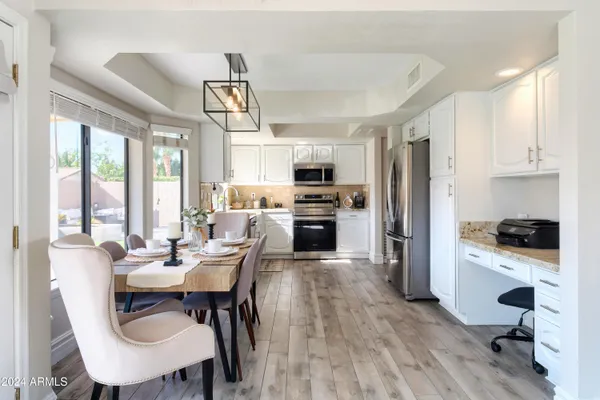 a view of a dining room with furniture a chandelier and wooden floor