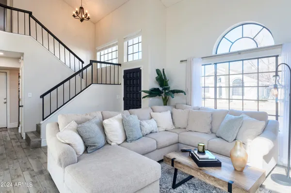a living room with furniture and a large window with wooden floor