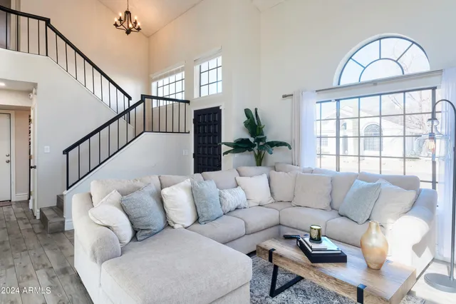a living room with furniture and a large window with wooden floor
