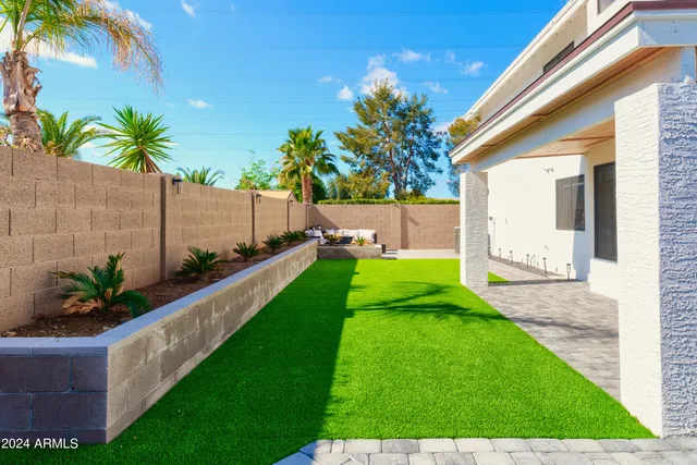 a view of a house with a yard and potted plants
