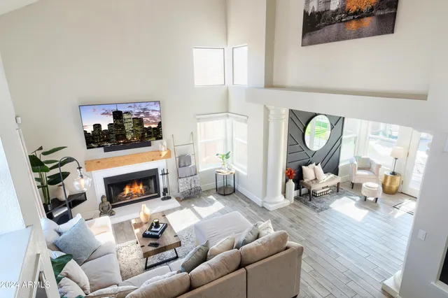 a living room with furniture a flat screen tv and a fireplace