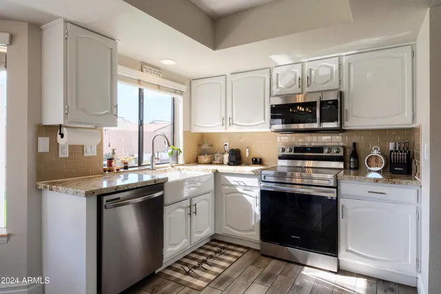 a kitchen with stainless steel appliances granite countertop a sink stove and microwave