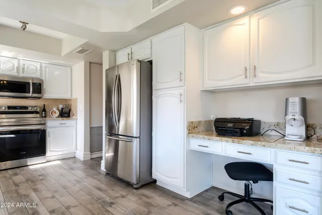 a kitchen with granite countertop a refrigerator stove and microwave
