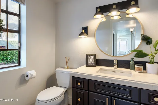 a bathroom with a toilet a sink and a mirror