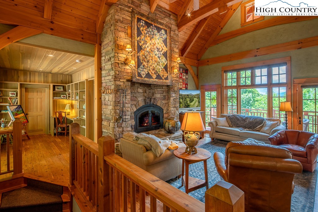 138 Mulberry Lane Boone, NC 28607 - Photo 2 of 33 a living room with furniture a fireplace and a floor to ceiling window