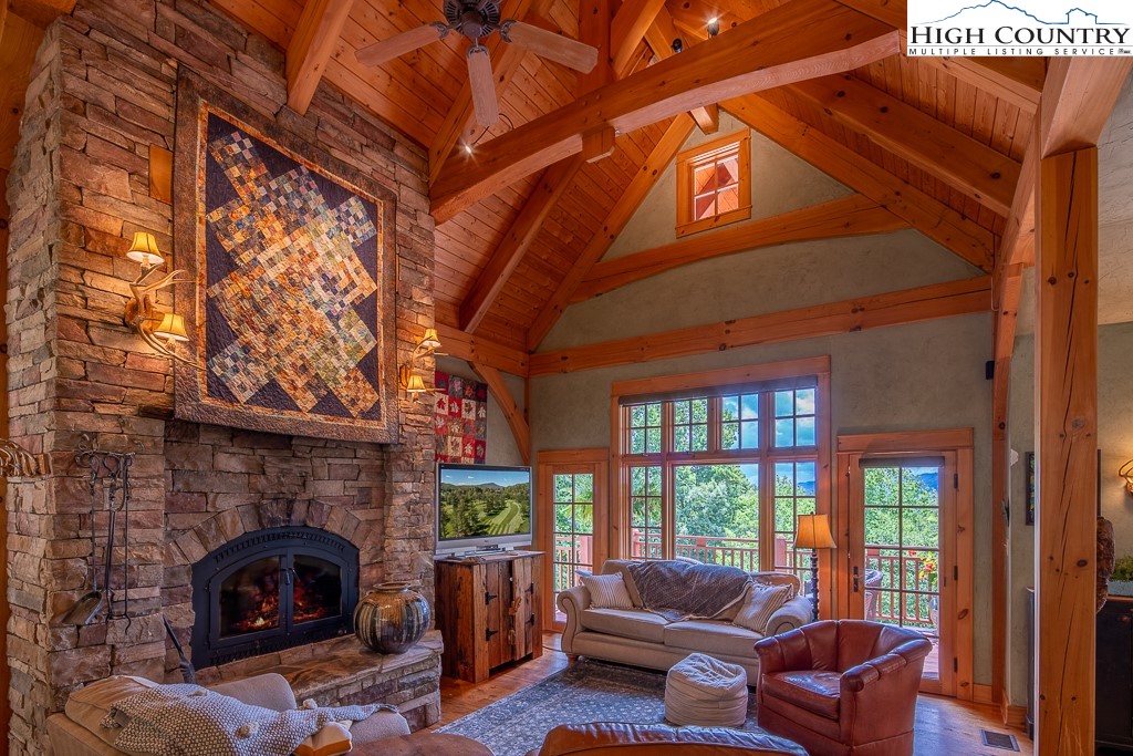 138 Mulberry Lane Boone, NC 28607 - Photo 3 of 33 a living room with furniture a fireplace and a floor to ceiling window
