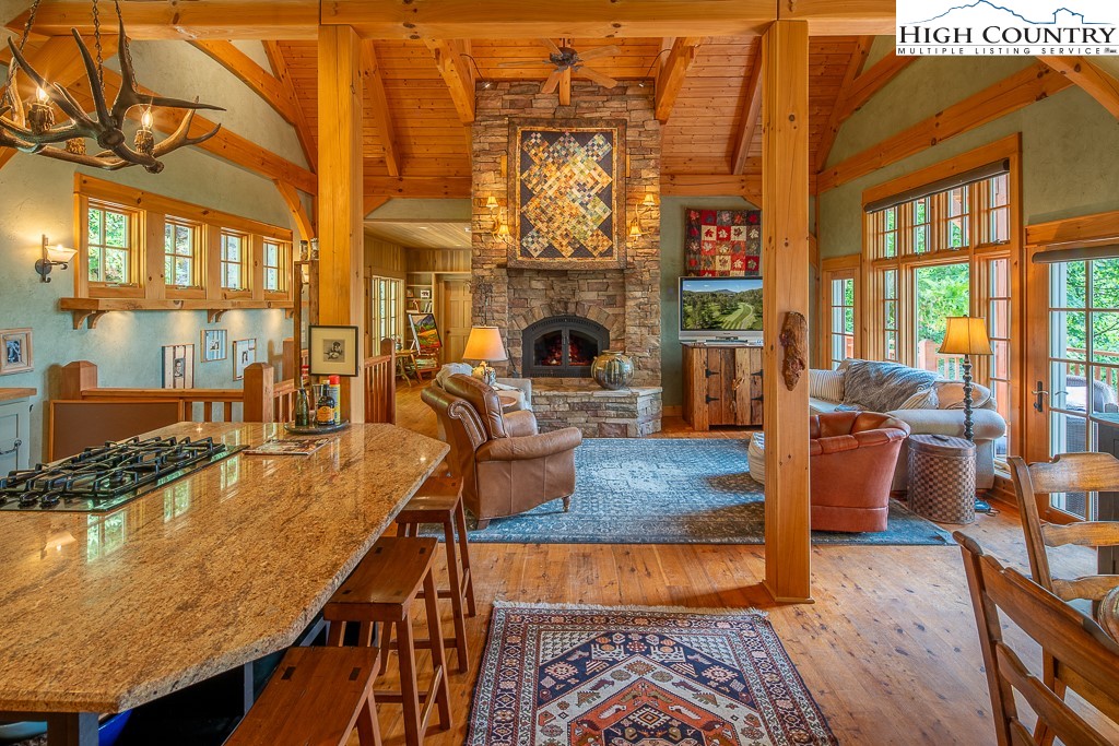 138 Mulberry Lane Boone, NC 28607 - Photo 7 of 33 a living room with furniture a fireplace and large windows