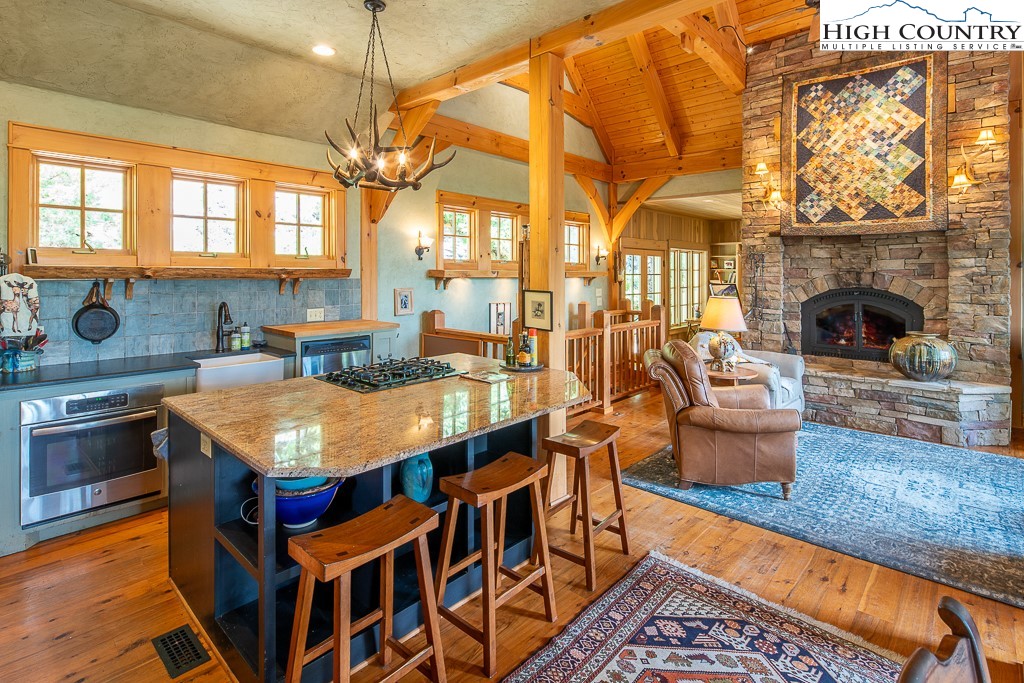 138 Mulberry Lane Boone, NC 28607 - Photo 8 of 33 a kitchen with stainless steel appliances granite countertop a stove a sink and a dining table with wooden floor