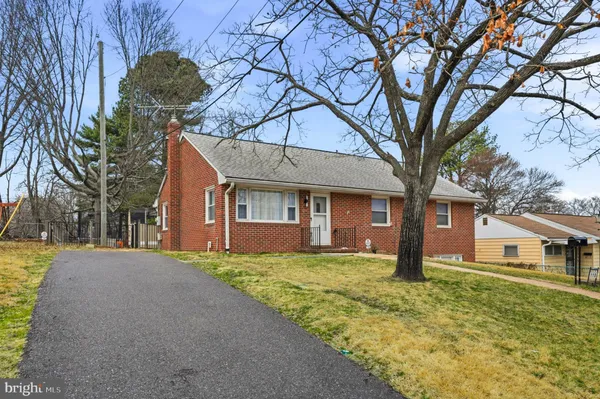 a view of a house with a yard and large tree