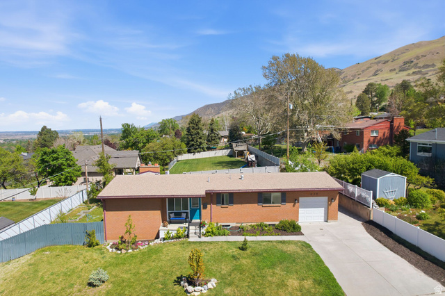 935 900 North Bountiful, UT 84010 - Photo 41 of 46 View of front of property with brick siding, driveway, a mountain view, a residential view, and an attached garage