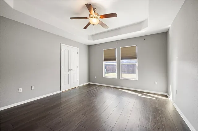 a view of an empty room with window and wooden floor