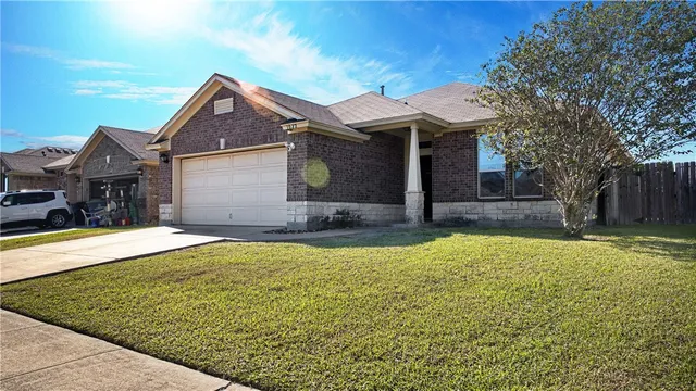 a front view of house with yard and trees in the background