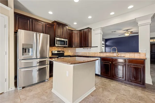 a kitchen with stainless steel appliances granite countertop a refrigerator stove a sink and a microwave