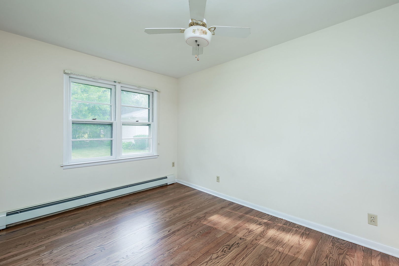 1170 South Broadway Road Montgomery, IL 60538 - Photo 19 of 25 an empty room with wooden floor ceiling fan and windows