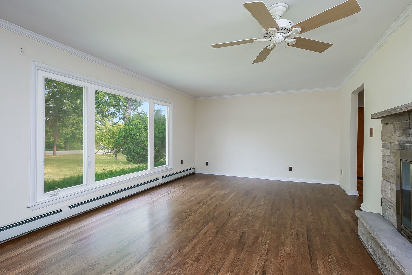 1170 South Broadway Road Montgomery, IL 60538 - Photo 6 of 25 a view of an empty room with a window and wooden floor