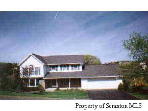 a view of house with a yard and potted plants