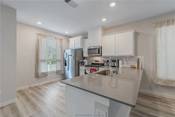 a kitchen with stainless steel appliances granite countertop a sink refrigerator and microwave
