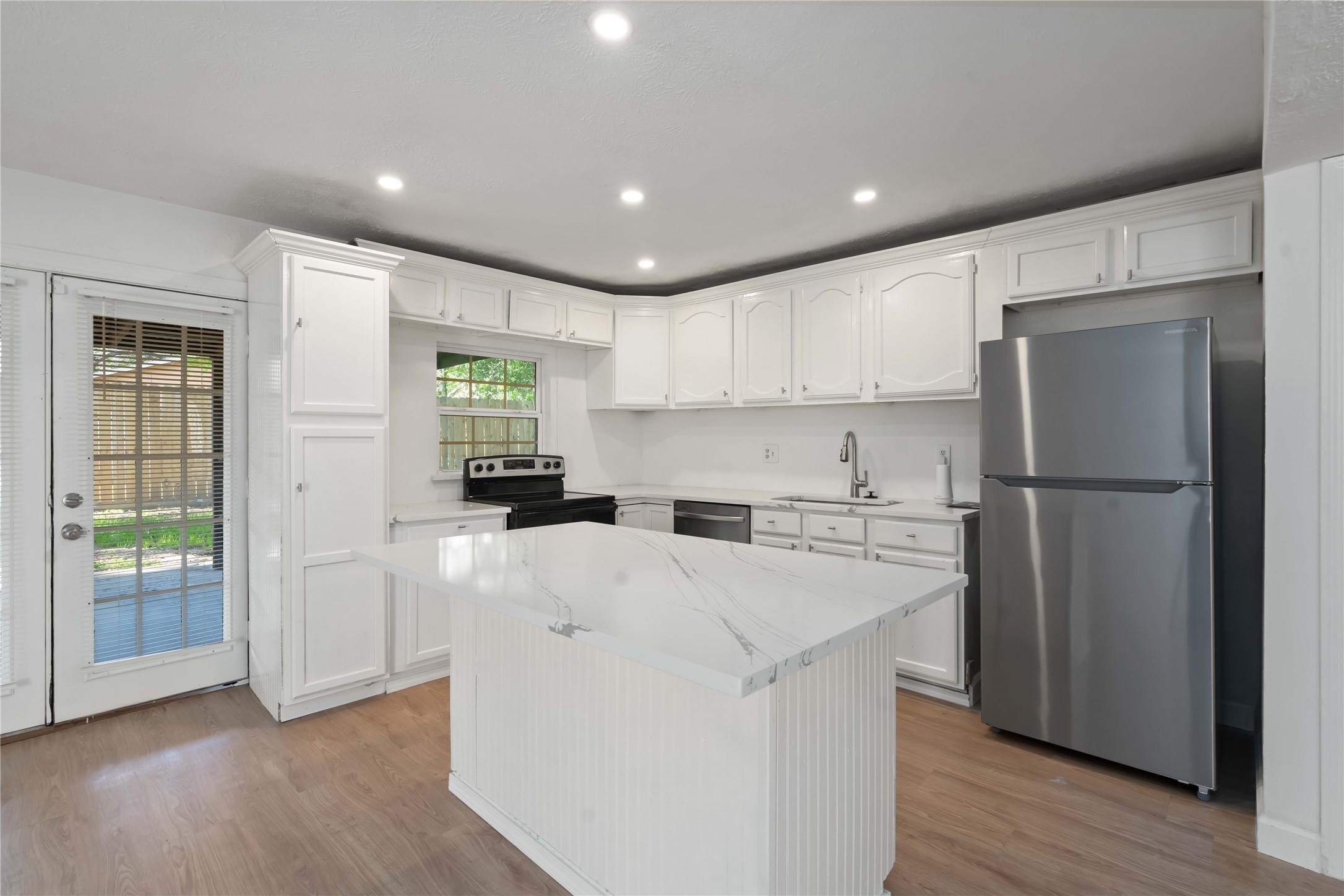 17415 North Barker Street Houston, TX 77084 - Photo 13 of 30 a kitchen with a refrigerator a stove top oven and wooden floor