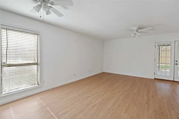 an empty room with a window and a ceiling fan