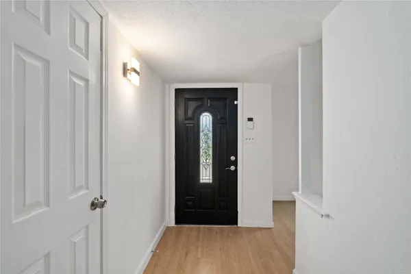 a view of a hallway with wooden floor and closet