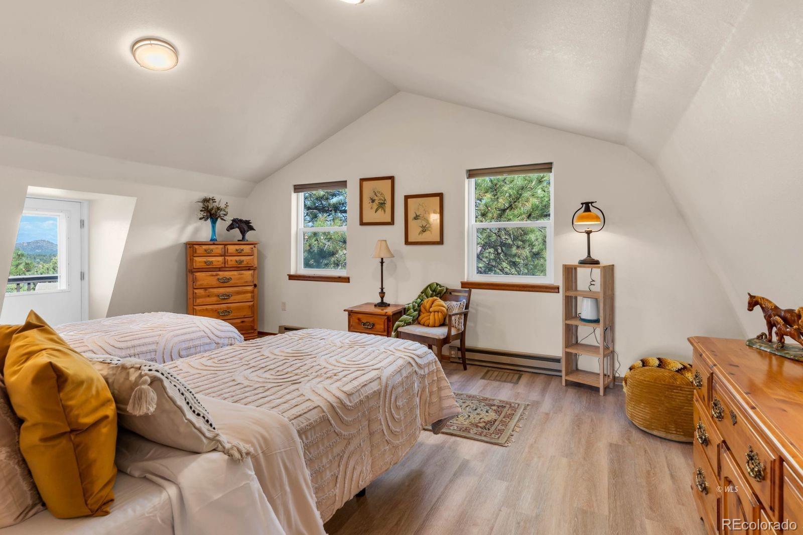 570 Rocky Ridge Road Westcliffe, CO 81252 - Photo 18 of 33 a bedroom with a bed and wooden floor