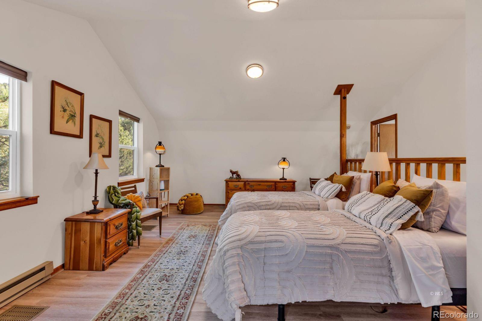 570 Rocky Ridge Road Westcliffe, CO 81252 - Photo 20 of 33 a bedroom with a bed and wooden floor