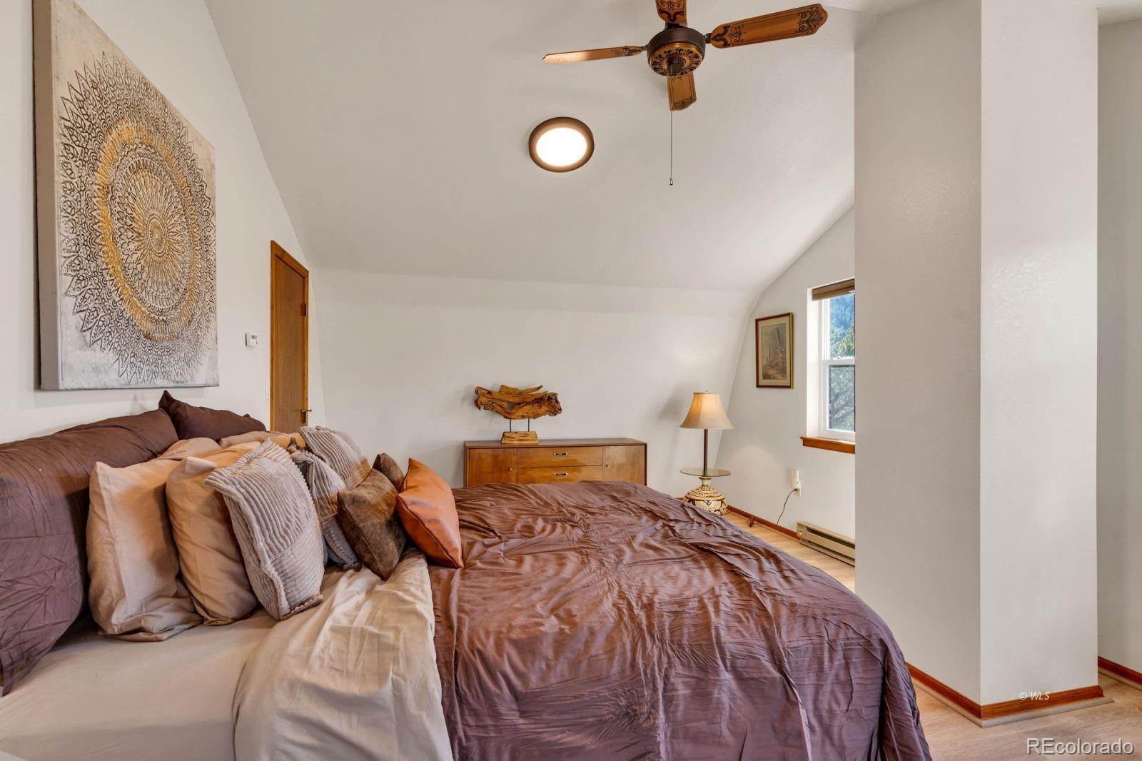 570 Rocky Ridge Road Westcliffe, CO 81252 - Photo 24 of 33 a bedroom with two beds and a chandelier