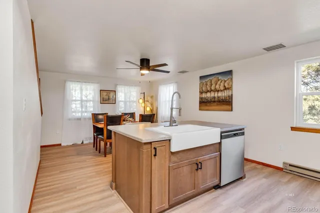 a view of a kitchen counter space a sink wooden floor and a window