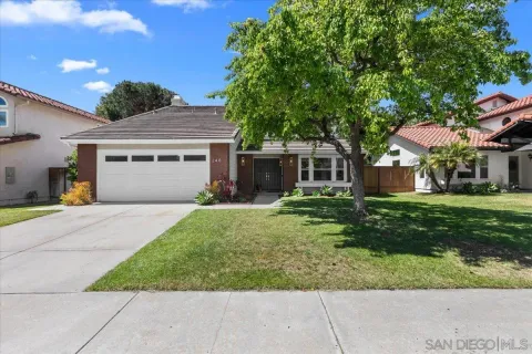 a front view of a house with a yard and potted plants