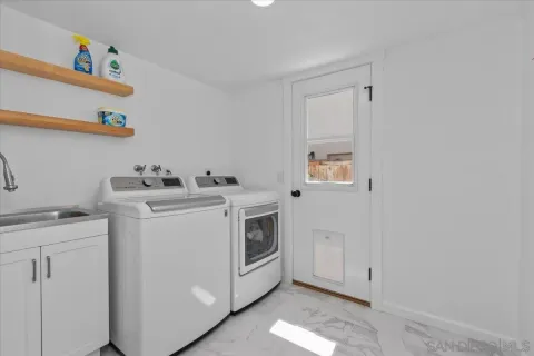 a utility room with cabinets washer and dryer