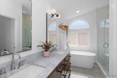 a bathroom with a granite countertop sink mirror and bathtub