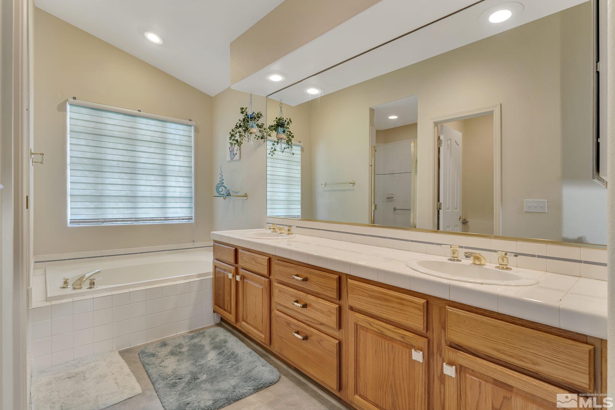 2560 Granite Springs Road Reno, NV 89519 - Photo 18 of 33 a bathroom with a granite countertop sink mirror and a bathtub