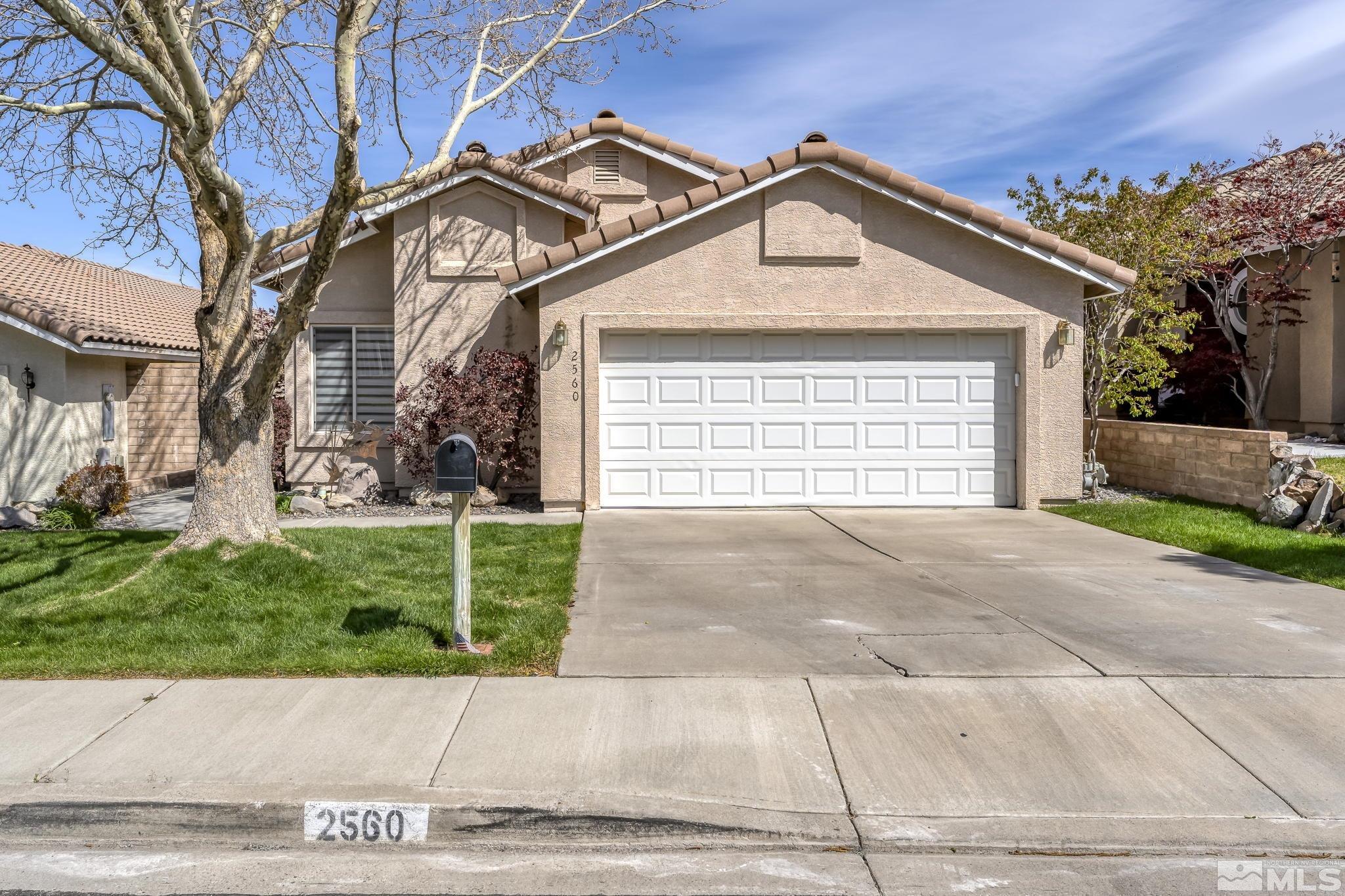 2560 Granite Springs Road Reno, NV 89519 - Photo 2 of 33 a front view of a house with a yard and garage