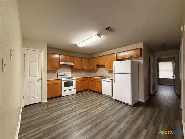 a kitchen with a refrigerator and a stove top oven