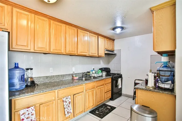 a kitchen with stainless steel appliances granite countertop a sink a stove and cabinets