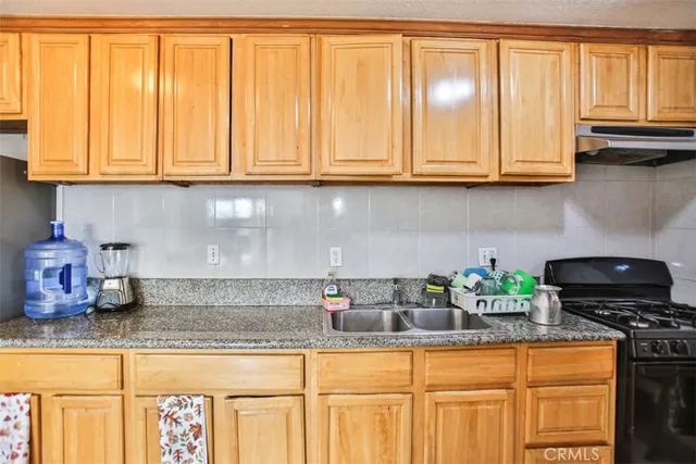 a kitchen with a sink a stove and cabinets