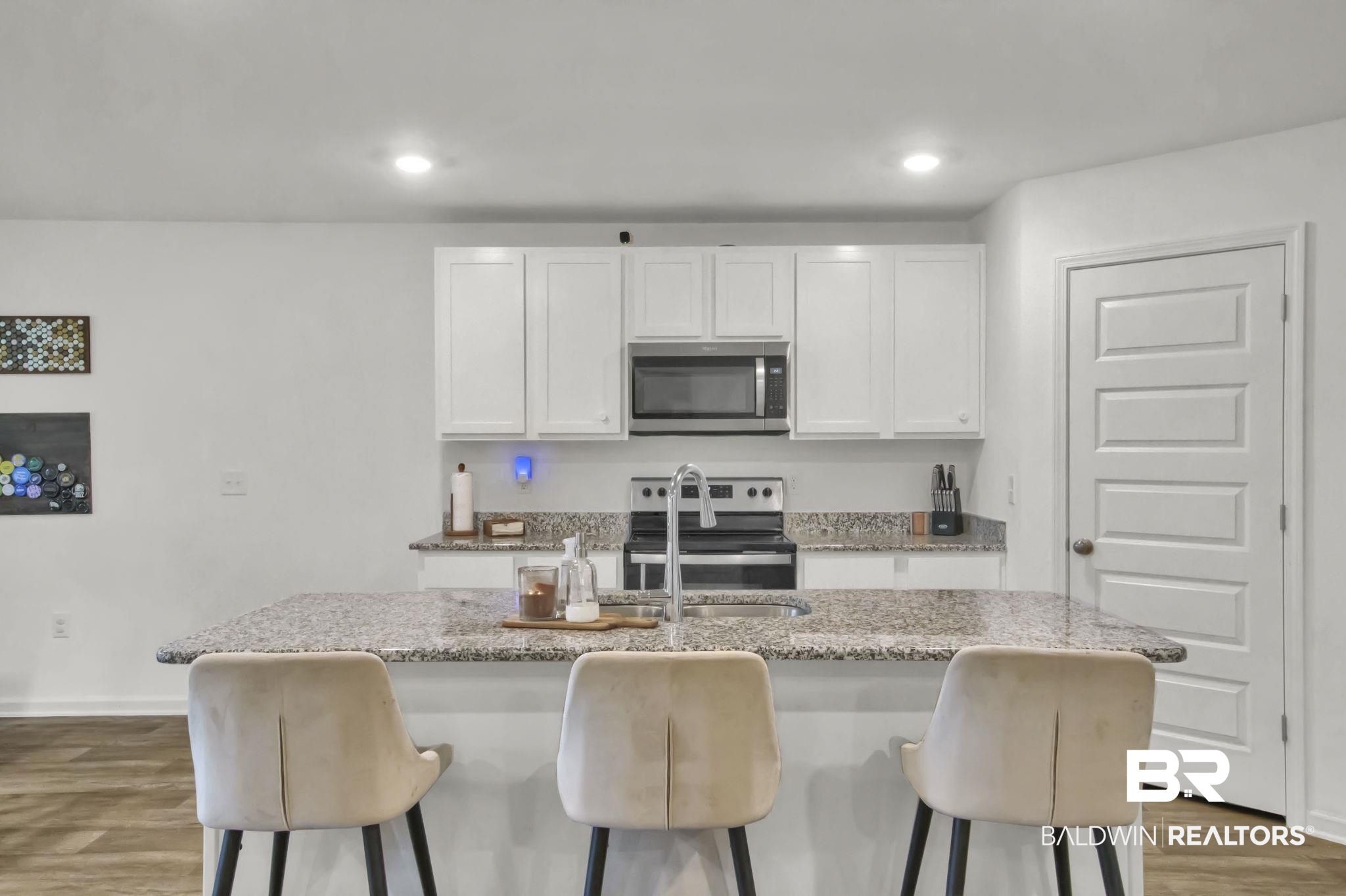 23810 Unbridled Loop Daphne, AL 36526 - Photo 14 of 50 Kitchen featuring dark wood-type flooring, stainless steel appliances, an island with sink, and white cabinetry