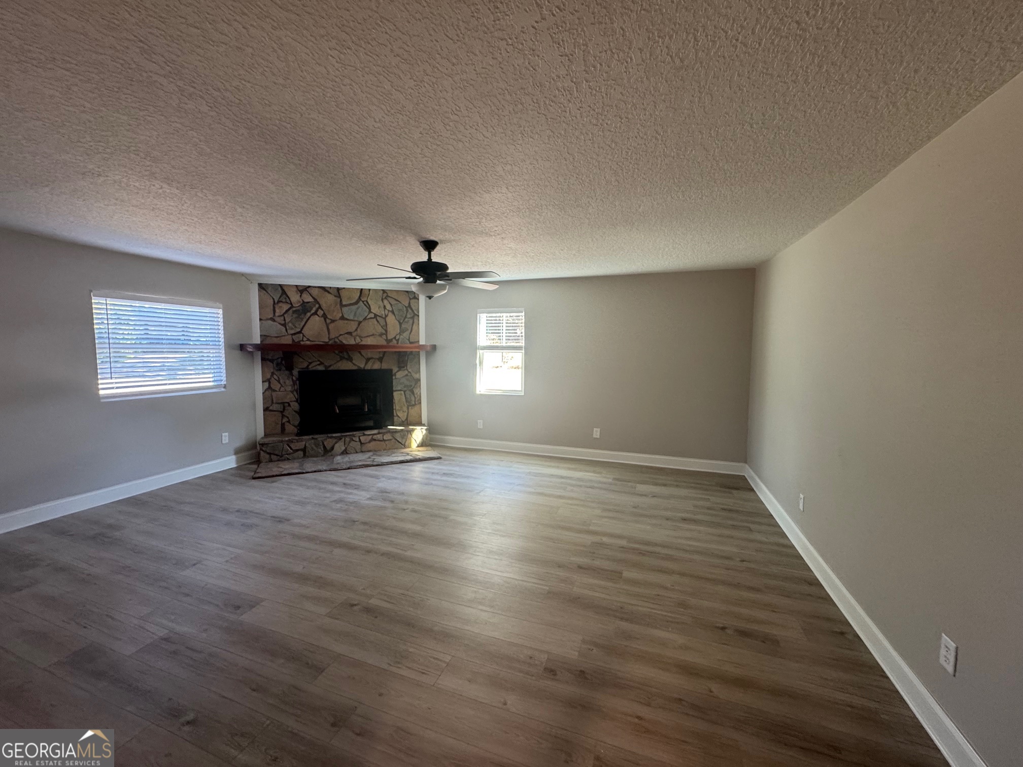 2199 Tom Crawford Road Hilliard, FL 32046 - Photo 8 of 18 an empty room with wooden floor fireplace and windows