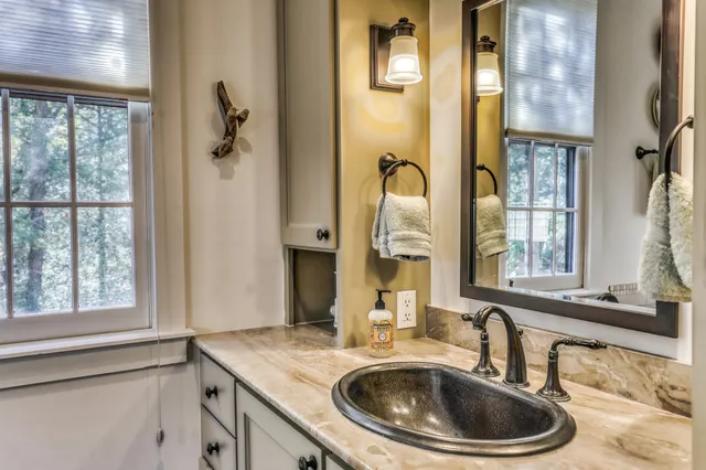 a bathroom with a sink a mirror and a window
