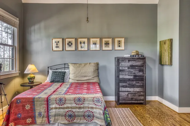 a large bed sitting in a bedroom next to a window