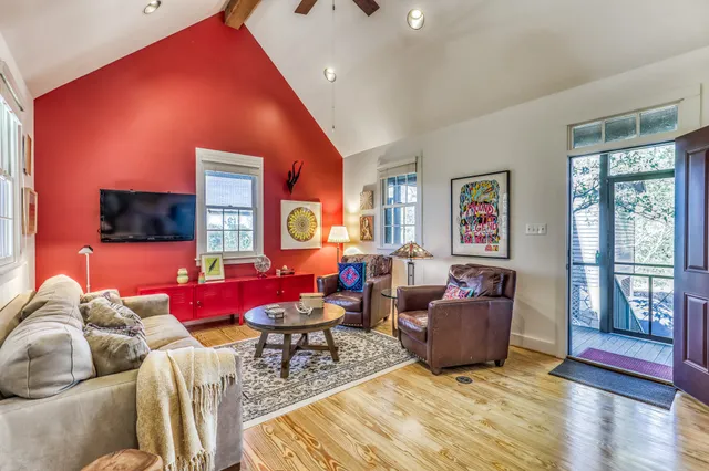 a living room with furniture a flat screen tv and floor to ceiling window