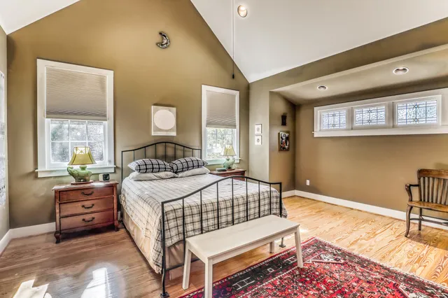 a bedroom with a bed window and a table in it