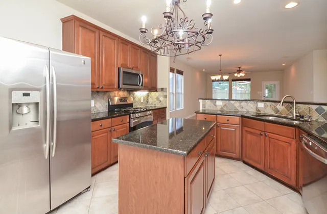 a view of a kitchen with a sink and a chandelier fan