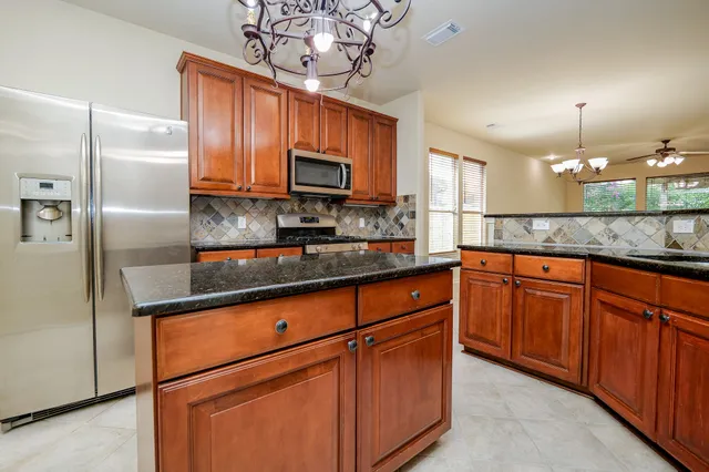 a kitchen with a sink a counter top space cabinets and stainless steel appliances